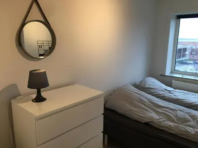 a bedroom with a bed and a mirror and a dresser at Malthe Bruuns Vej 17, 1. sal in Thisted