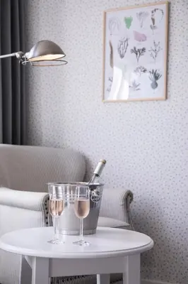 a table with two wine glasses and a bottle on it at Tambohus Kro & Badehotel in Hvidbjerg