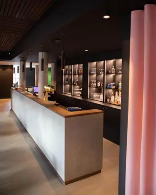 a bar in a restaurant with a counter at Struer Grand Hotel in Struer