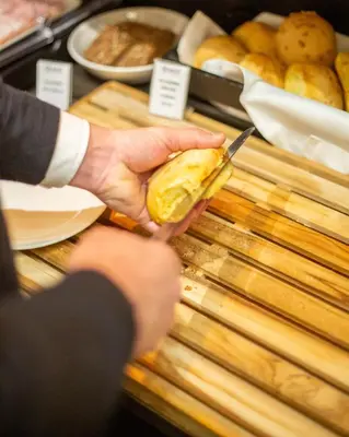 a person is cutting a pineapple with a knife at Struer Grand Hotel in Struer