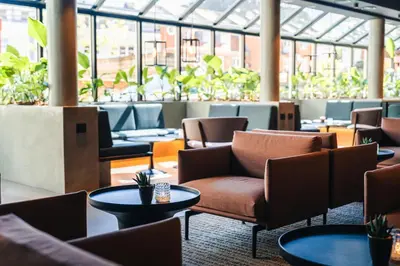 a lobby with chairs and tables and plants at Struer Grand Hotel in Struer
