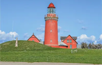 a red lighthouse sitting on top of a hill at Three-Bedroom Holiday Home In Harboore in Harboør