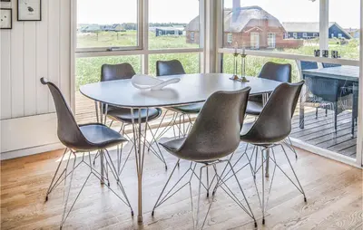 a table and chairs in a room with a large window at Three-Bedroom Holiday Home In Harboore in Harboør