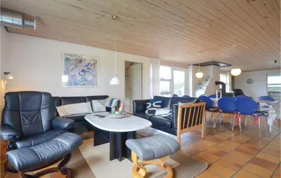 a living room with a couch and a table and chairs at Five-Bedroom Holiday Home In Thisted in Thisted