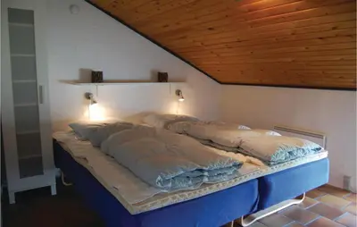 a large bed in a room with a wooden ceiling at Five-Bedroom Holiday Home In Thisted in Thisted