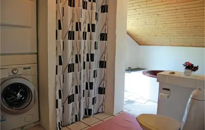 a bathroom with a washing machine in a room at Five-Bedroom Holiday Home In Thisted in Thisted