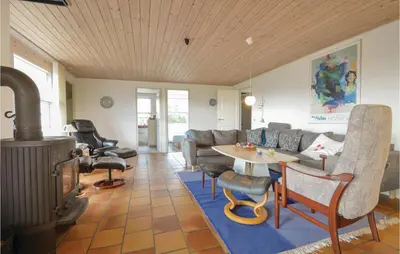 a living room with a couch and a table and a stove at Five-Bedroom Holiday Home In Thisted in Thisted
