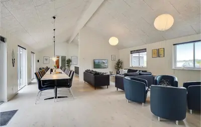 a living room with a dining table and chairs at Lovely Home In Spøttrup With Sauna in Spottrup