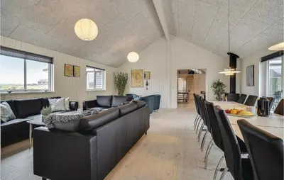 a living room with black leather furniture and a table at Lovely Home In Spøttrup With Sauna in Spottrup