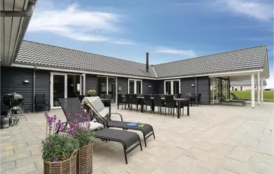 a patio with black furniture and tables and chairs at Lovely Home In Spøttrup With Sauna in Spottrup