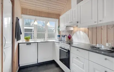 a white kitchen with white cabinets and a window at Three-Bedroom Holiday Home In Logstor in Løgstør