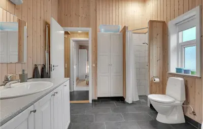 a bathroom with a white toilet and a sink at Three-Bedroom Holiday Home In Logstor in Løgstør