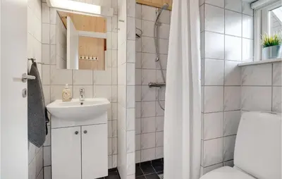 a white bathroom with a sink and a toilet at Three-Bedroom Holiday Home In Logstor in Løgstør