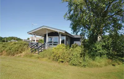 a house on the side of a hill with a tree at Three-Bedroom Holiday Home In Hurup Thy in Doverodde