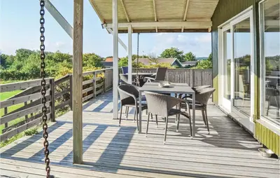a porch with a table and chairs on it at Three-Bedroom Holiday Home In Hurup Thy in Doverodde