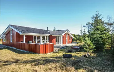 a red house in the middle of a yard at Four-Bedroom Holiday Home In Fjerritslev in Fjerritslev