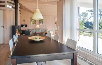 a dining room with a black table and white chairs at Four-Bedroom Holiday Home In Fjerritslev in Fjerritslev