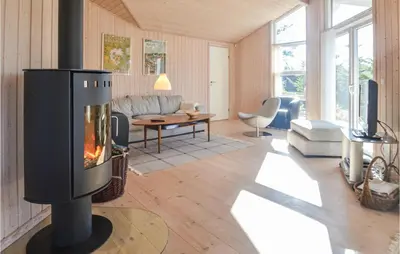a living room with a fireplace in the middle at Four-Bedroom Holiday Home In Fjerritslev in Fjerritslev
