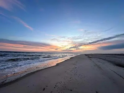 a beach with a sunset and the ocean at Secluded Beach Retreat in Rodhus-By Traum in Pandrup