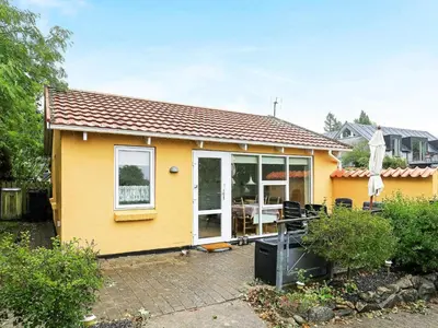 a yellow house with a large sliding glass door at 4 person holiday home in Nykøbing M-By Traum in Refshammer
