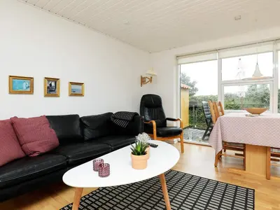 a living room with a black couch and a table at 4 person holiday home in Nykøbing M-By Traum in Refshammer