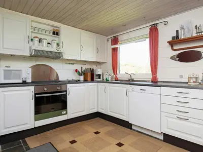 a white kitchen with white cabinets and a window at 6 person holiday home in Farsø-By Traum in Farsø