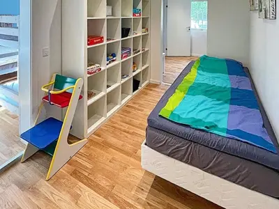 a bedroom with a colorful bed and a chair at Spacious Family Retreat - By Traum Ferienwohnungen in Skals