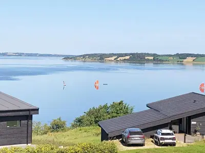 a lake with two cars parked next to a building at Modern Retreat with View - By Traum Ferienwohnungen in Løgstrup