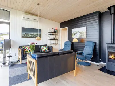 a living room with a fireplace and blue chairs at Modern Retreat with View - By Traum Ferienwohnungen in Løgstrup