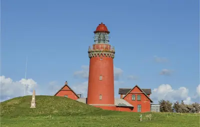 a red lighthouse sitting on top of a hill at Three-Bedroom Holiday Home In Lemvig in Lemvig