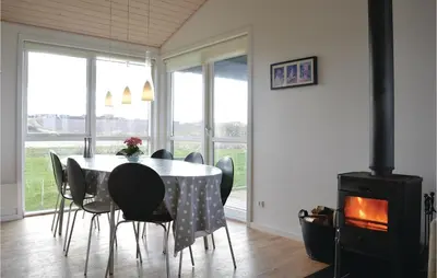 a dining room with a table and chairs and a stove at Three-Bedroom Holiday Home In Lemvig in Lemvig