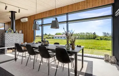 a dining room with a table and chairs and a large window at Two-Bedroom Holiday Home In Vinderup in Vinderup
