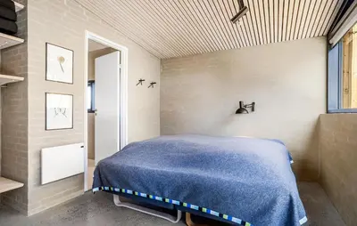 a bedroom with a bed with a blue blanket at Two-Bedroom Holiday Home In Vinderup in Vinderup