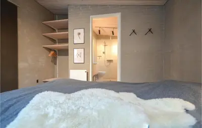 a bedroom with a bed with white fur on it at Two-Bedroom Holiday Home In Vinderup in Vinderup