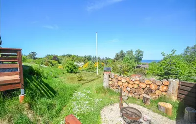 a yard with a fence and a pile of logs at Three-Bedroom Holiday Home In Fur in Fur