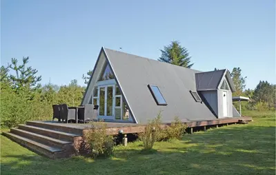 a tiny house with a pitched roof on a deck at Two-Bedroom Holiday Home In Logstor in Løgstør