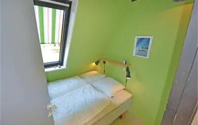 a small bedroom with a bed and a window at Two-Bedroom Holiday Home In Logstor in Løgstør
