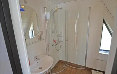 a white bathroom with a shower and a sink at Two-Bedroom Holiday Home In Logstor in Løgstør