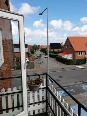 a balcony with a basket of flowers on a street at Bed and Breakfast i Struer in Struer