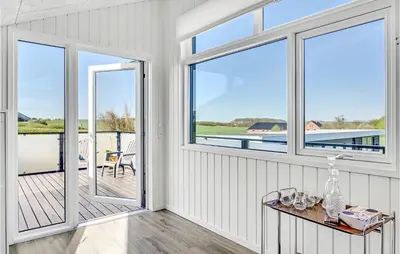 a room with windows and a table with glasses on it at Two-Bedroom Holiday Home In Lemvig in Lemvig