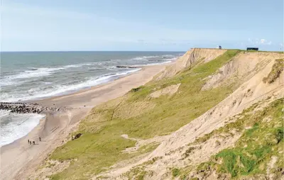 a group of people walking on a beach next to the ocean at Two-Bedroom Holiday Home In Lemvig in Lemvig