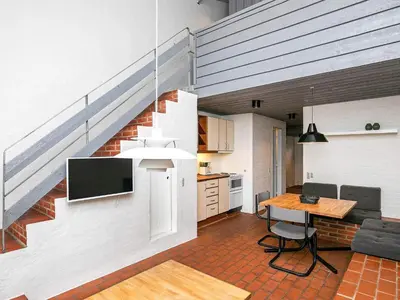 a kitchen and living room with a staircase in a house at 6 person holiday home in Brovst-By Traum in Brovst