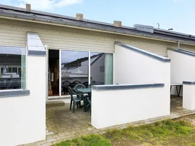 a white house with a patio and a table at 6 person holiday home in Brovst-By Traum in Brovst