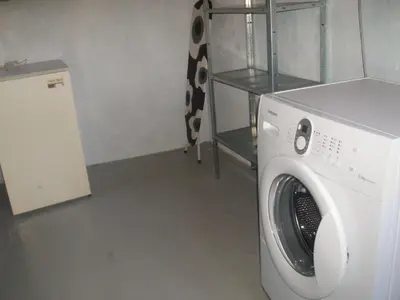 a white washing machine in a room with a shelf at 