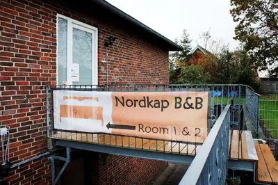 a sign on the side of a brick building at Nordkap Bed & Bath in Holstebro