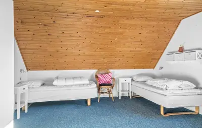 a room with two beds and a wooden ceiling at Four-Bedroom Holiday Home In Thyboron in Thyborøn