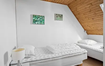a white bedroom with a bed and a wooden ceiling at Four-Bedroom Holiday Home In Thyboron in Thyborøn