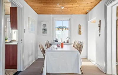 a dining room with a white table and chairs at Four-Bedroom Holiday Home In Thyboron in Thyborøn