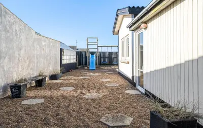 a courtyard between two buildings with a blue object in the middle at Four-Bedroom Holiday Home In Thyboron in Thyborøn