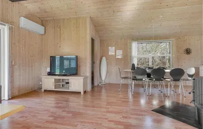 a living room with a table and chairs and a tv at Cozy Home In Roslev With Wifi in Roslev